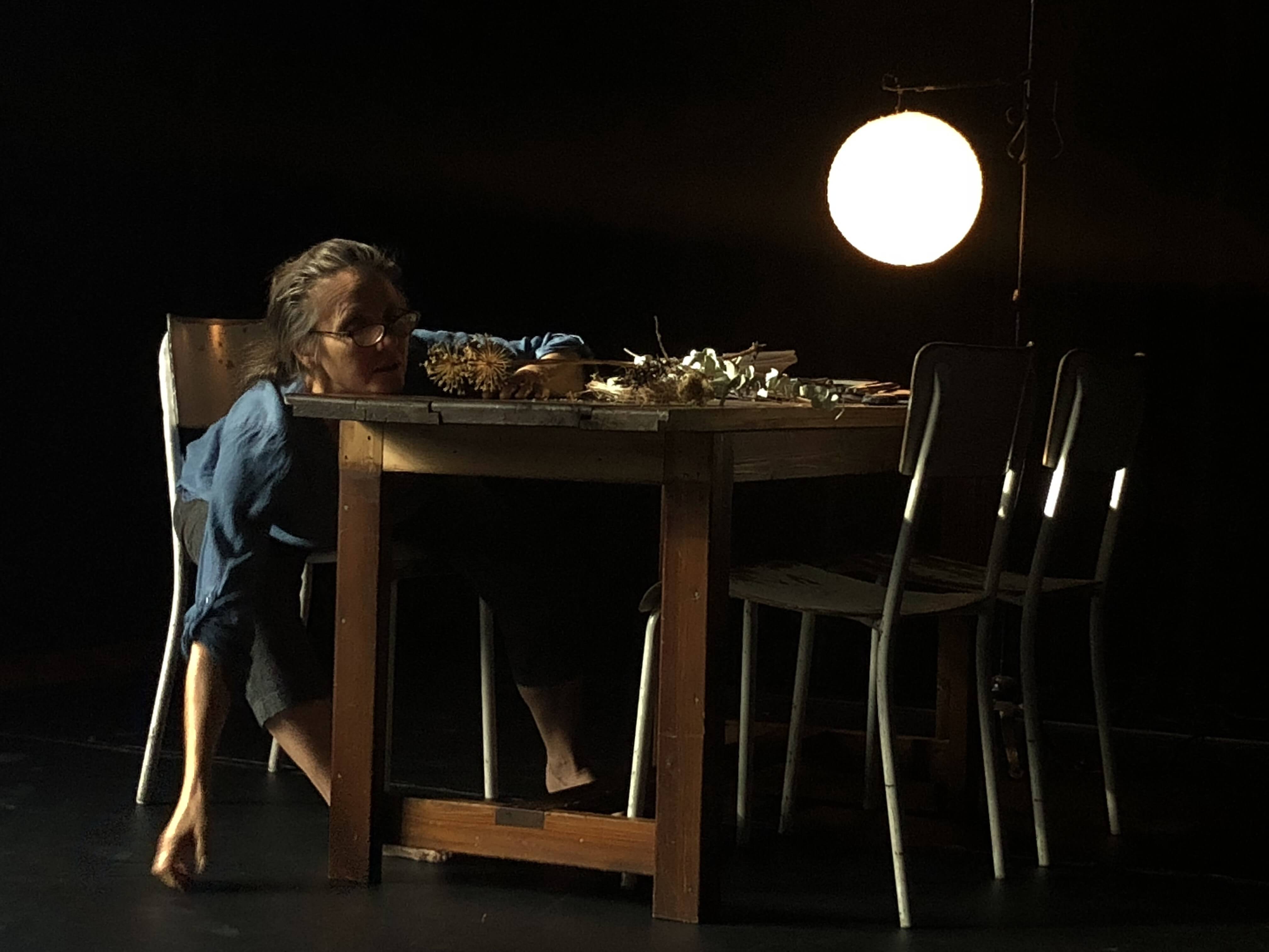 artist sliding down chair against table